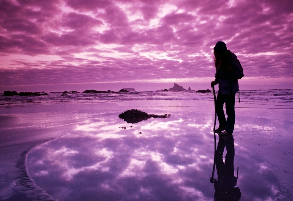 Person hiking with clouds and light reflected by the ground