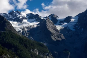 A breathtaking panoramic view of untamed forests, rugged mountains, and a wild river under an expansive sky, symbolizing the raw, authentic power of nature.